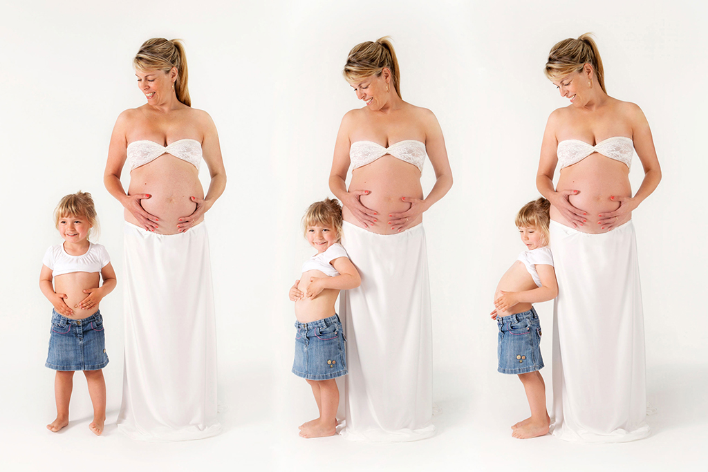 une femme enceinte avec sa fille sur fond blanc