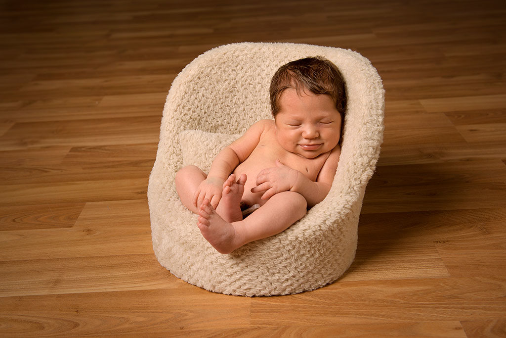 un nouveau né assis dans un pouf