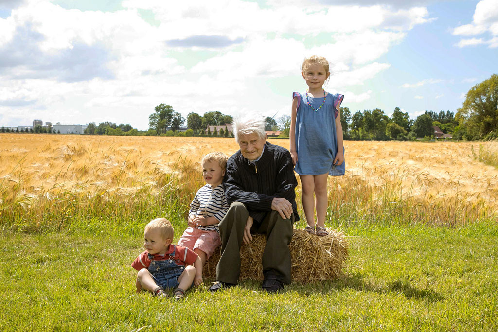 photo de famille arrière grand père et  arrière petits enfants devant un champs de blé