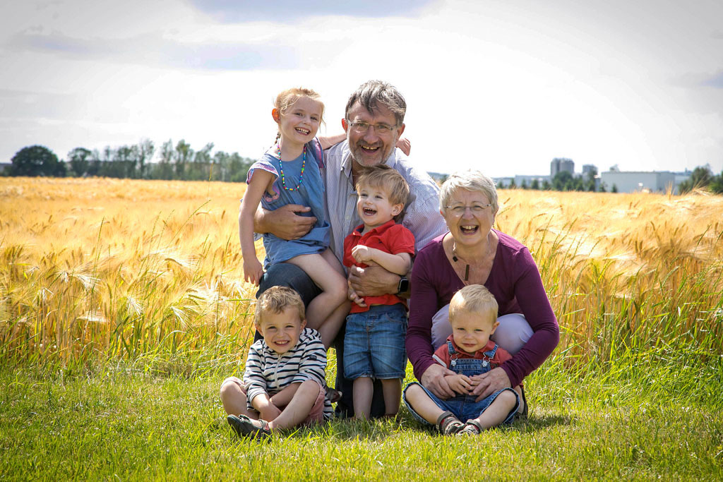 photo de famille grand parents et petits enfants devant un champs de blé