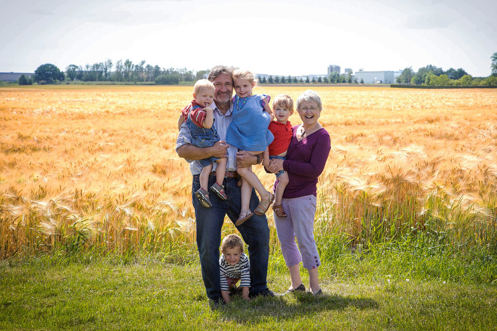 photo de famille grand parents et petits enfants devant un champs de blé