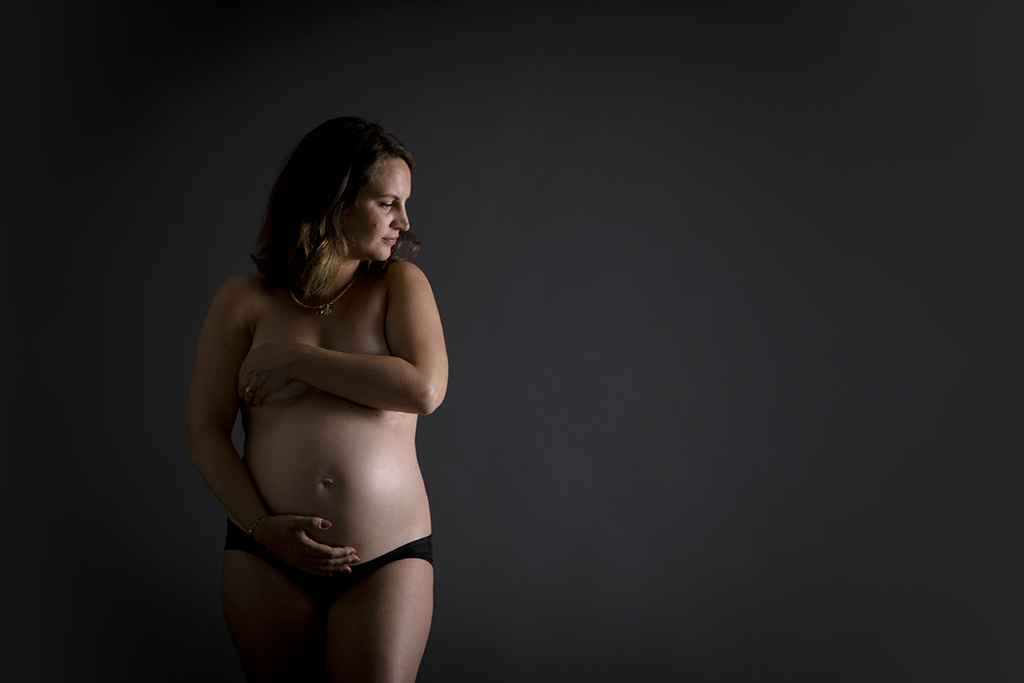 Photo de grossesse en studio fond noir
